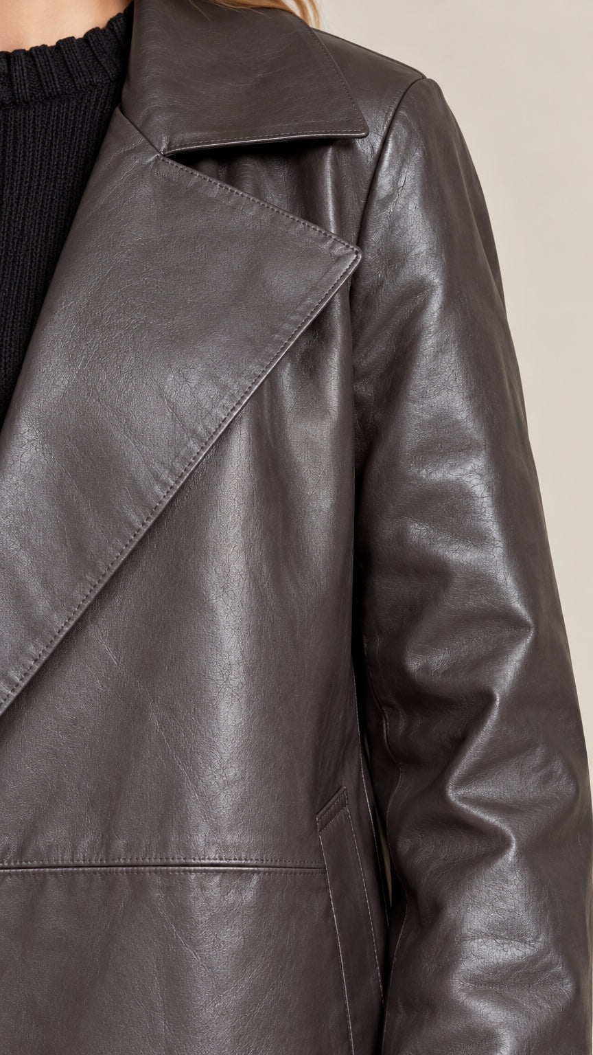 Close-up of wide notched lapel collar and smooth texture on dark brown leather-look coat