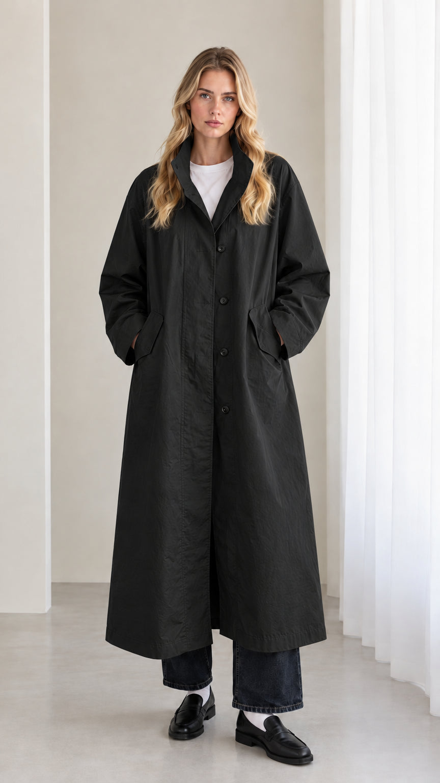 Front view of woman wearing black longline trench overcoat