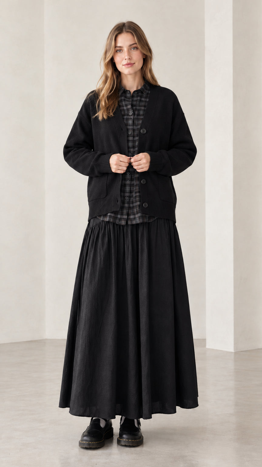 Front view of woman wearing black V-neck button-front knit cardigan sweater