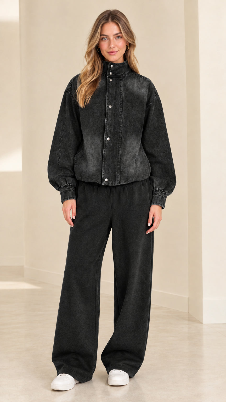 Model wearing washed black snap-front jacket and matching black wide-leg pants