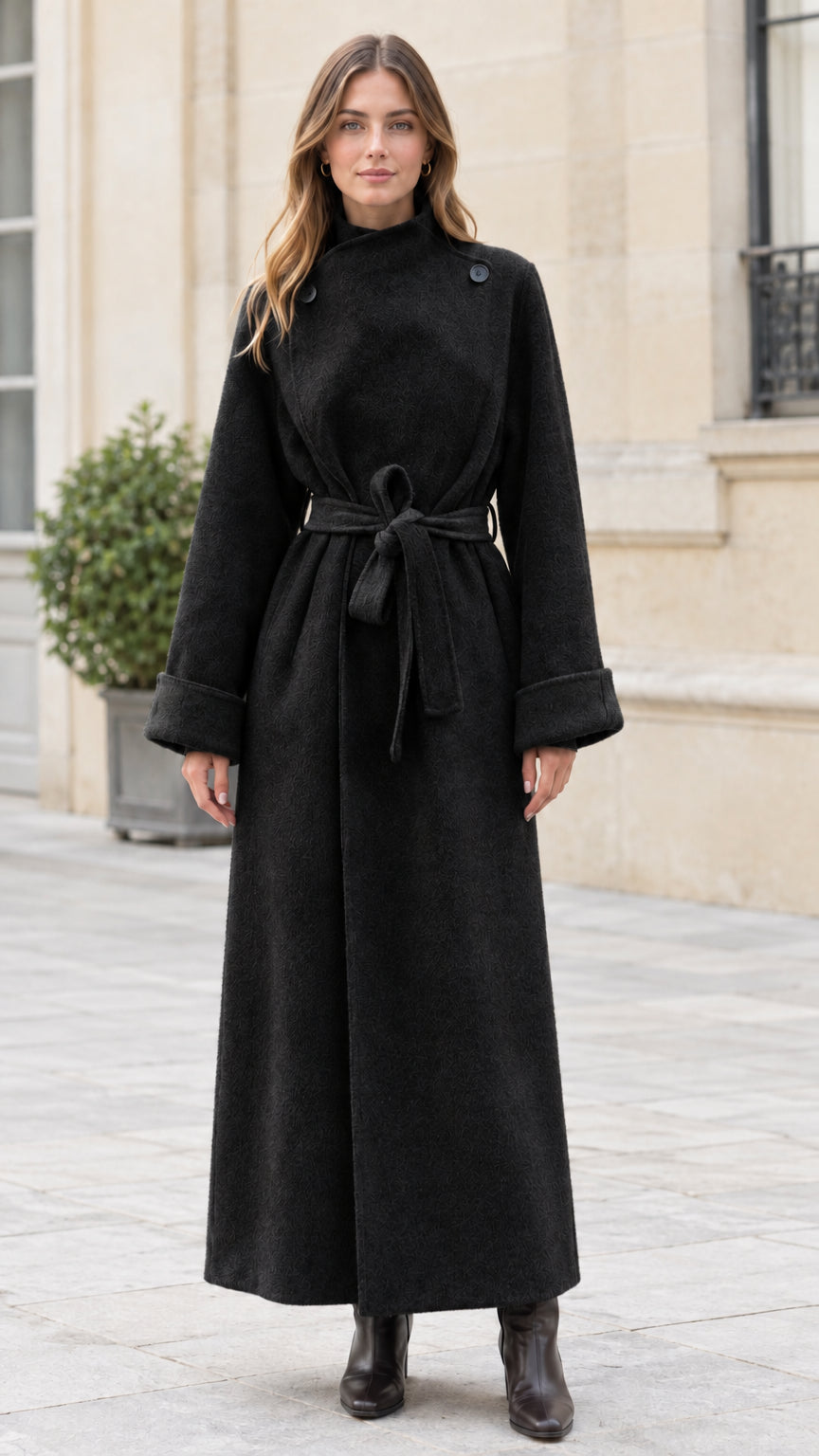 Model wearing black high neck belted maxi coat standing outdoors