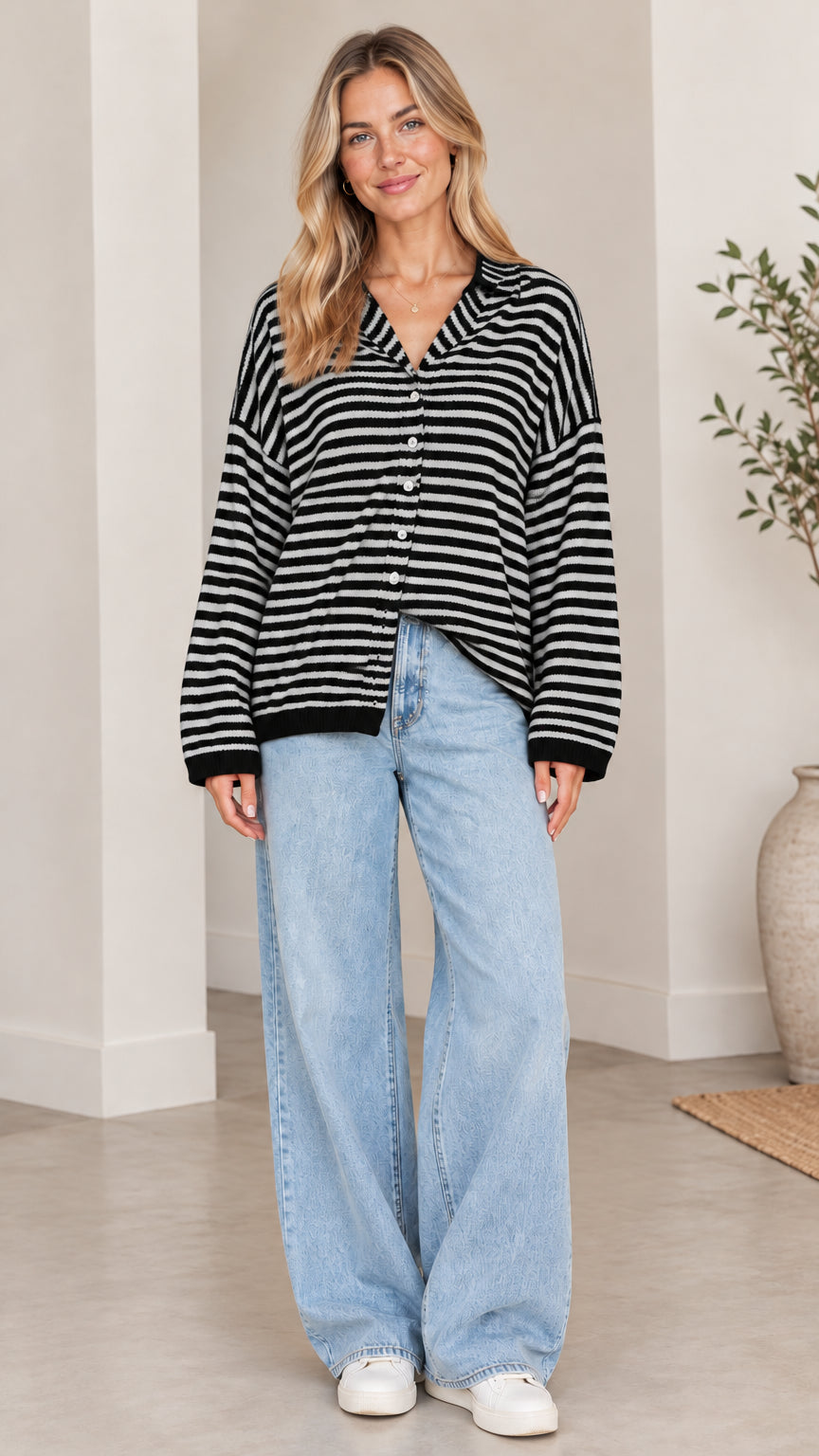 Front full-length view of woman wearing black and white striped collared cardigan sweater