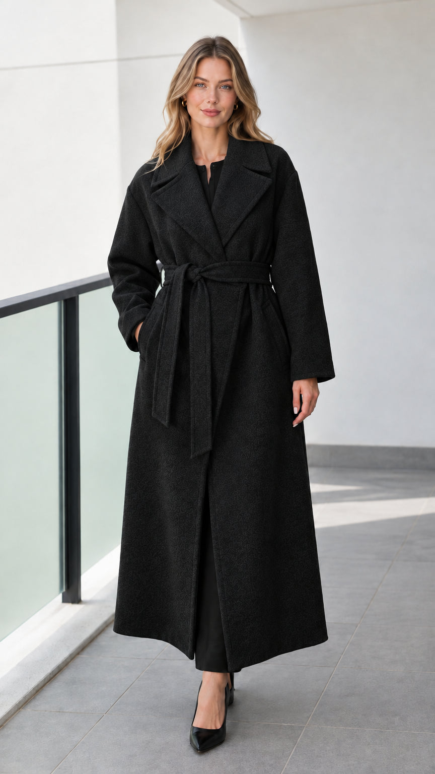 Full-length front view of model wearing black belted maxi wrap coat