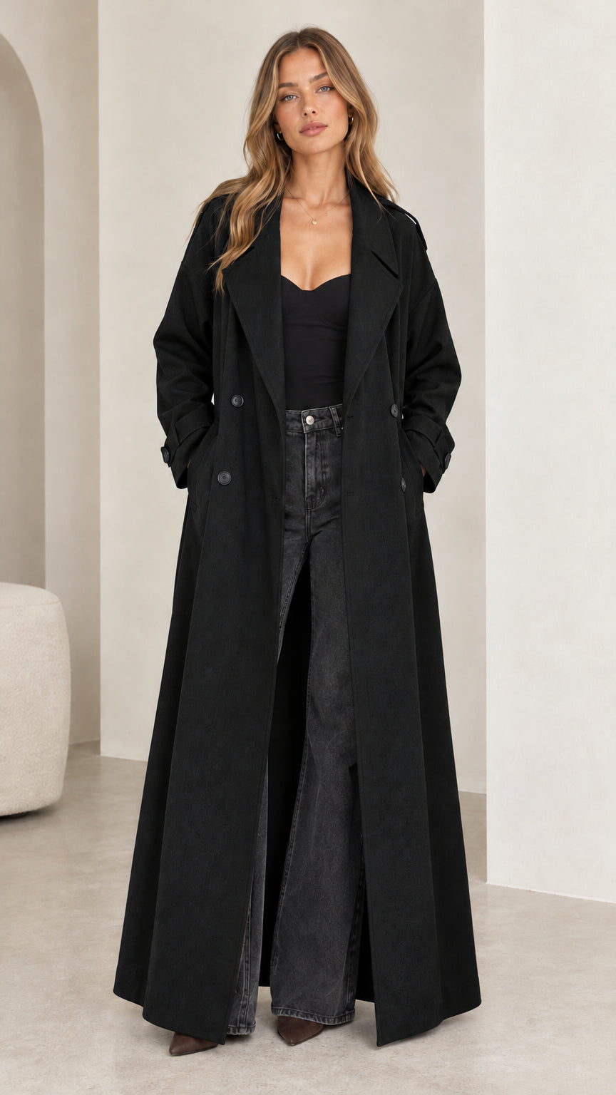 Full front view of model wearing the floor-length black double-breasted trench coat