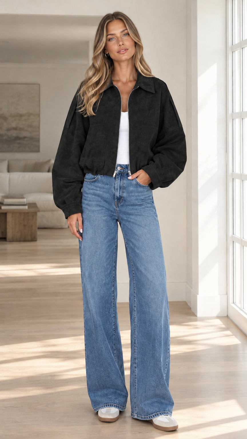 Front view of model wearing black cropped faux suede bomber jacket with wide leg denim