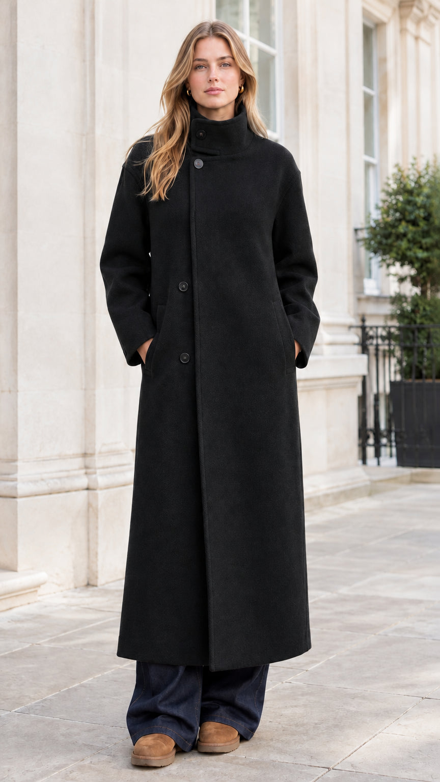Full-length front view of woman wearing elegant black high-neck buttoned overcoat