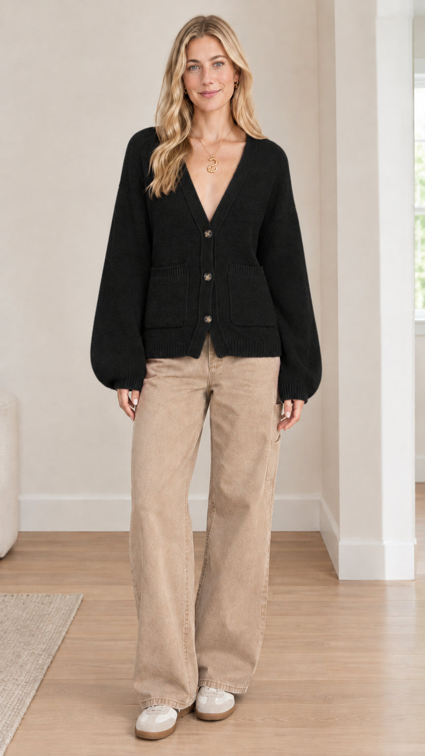 Front full-length view of model wearing black V-neck button-front cardigan with wide-leg pants