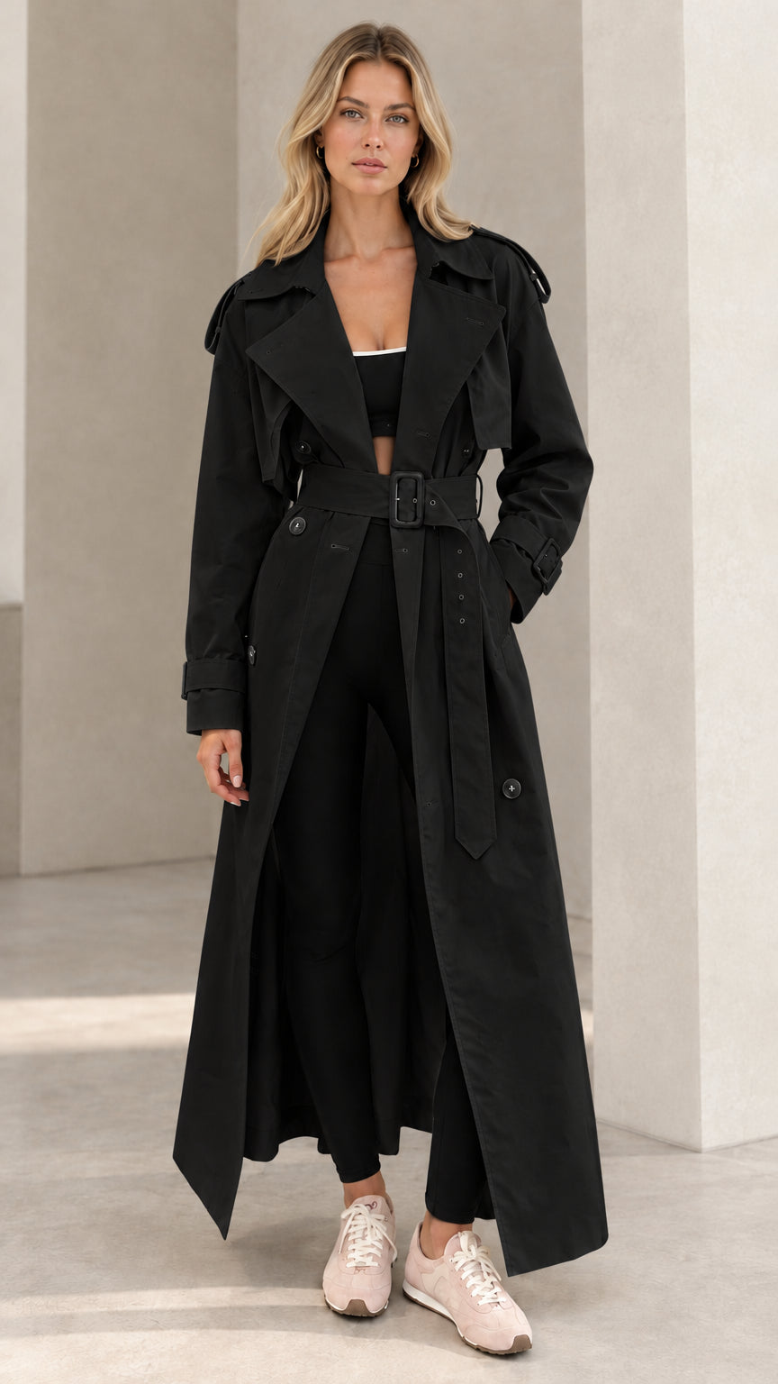 Front view of model wearing black double-breasted maxi trench coat