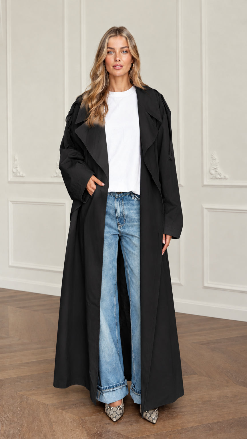 Front view of woman wearing oversized black floor-length trench coat