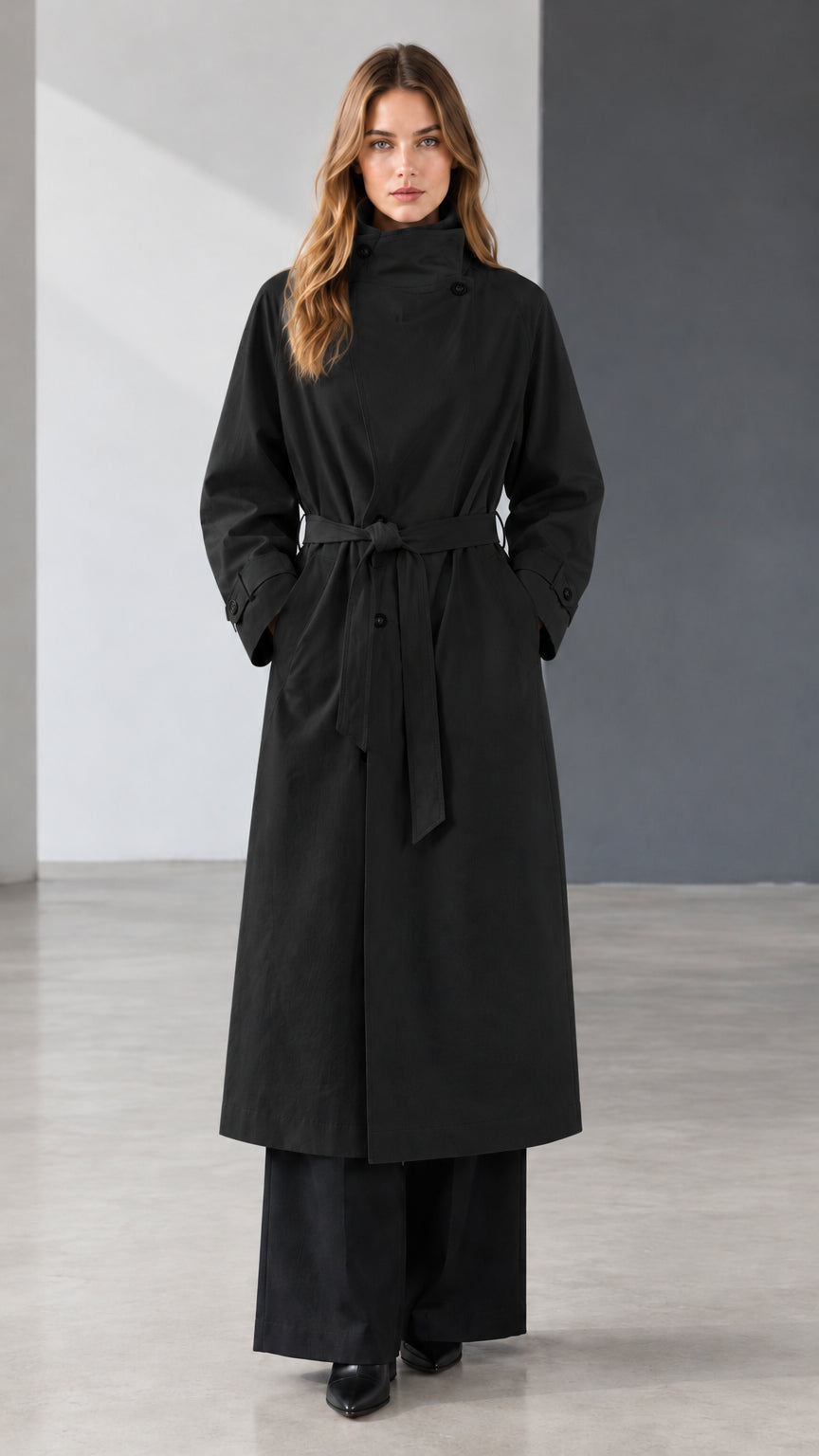 Front view of model wearing black belted longline trench coat