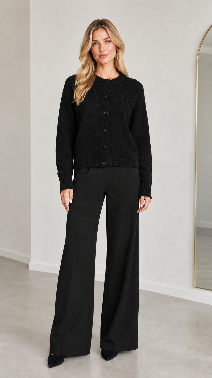 Front view of model wearing Black knit button-down cardigan and wide-leg trousers