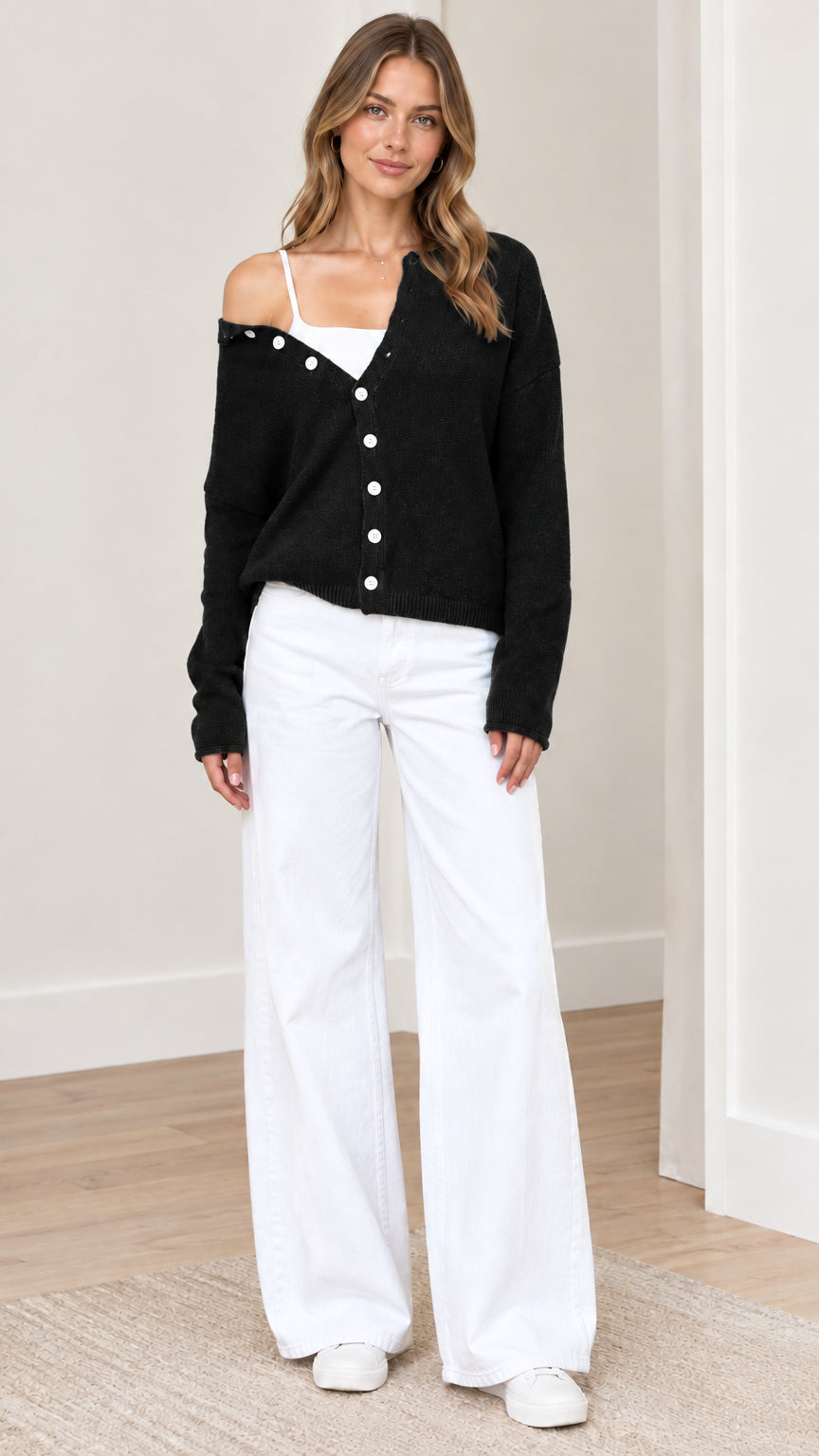 Front view of woman wearing black asymmetrical button-down knit cardigan sweater