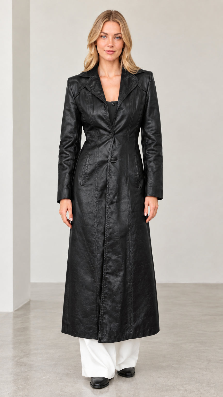 Full-length front view of woman wearing black textured faux leather maxi trench coat