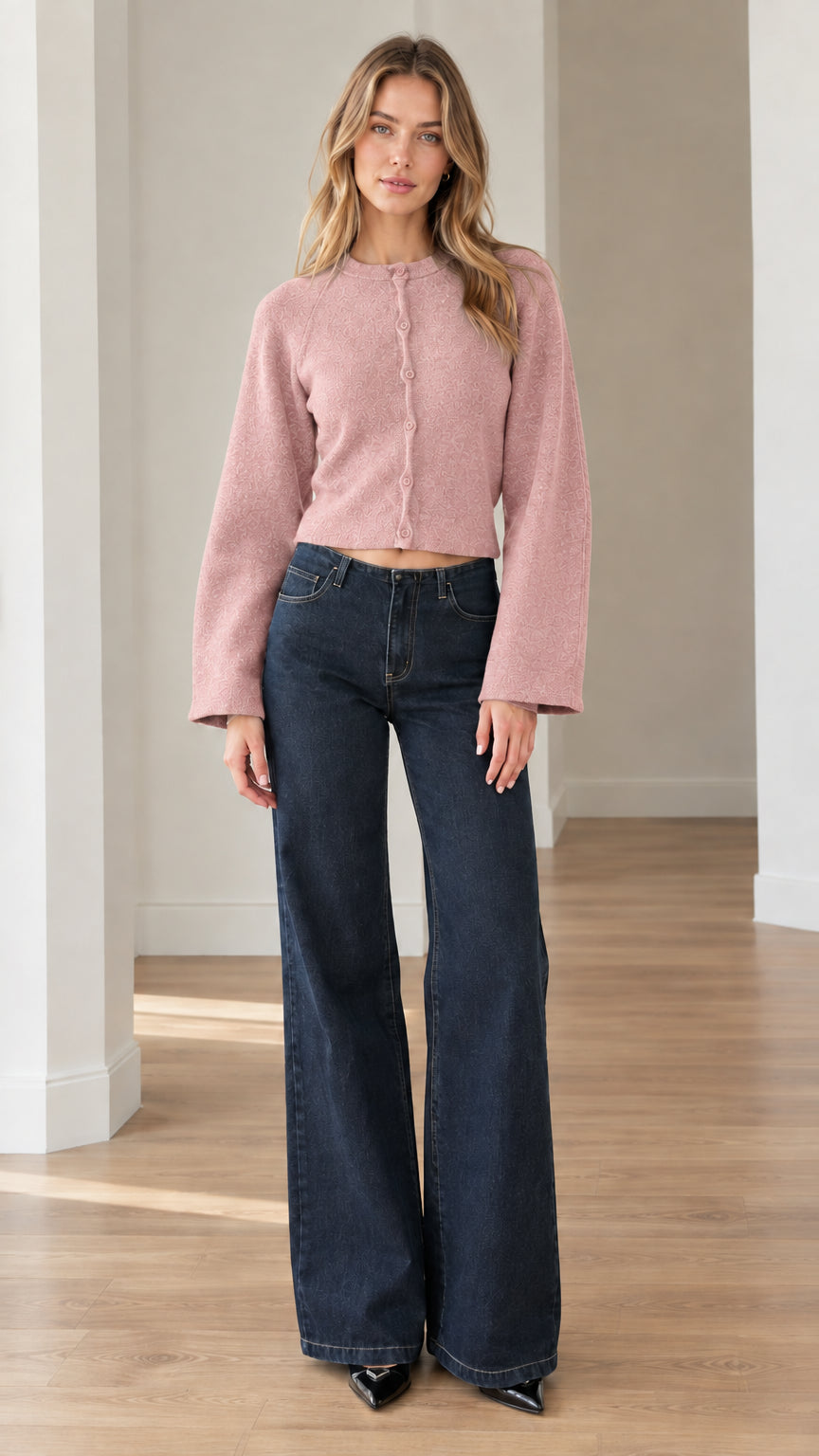 Model wearing dusty pink cropped knit cardigan paired with dark wash denim jeans