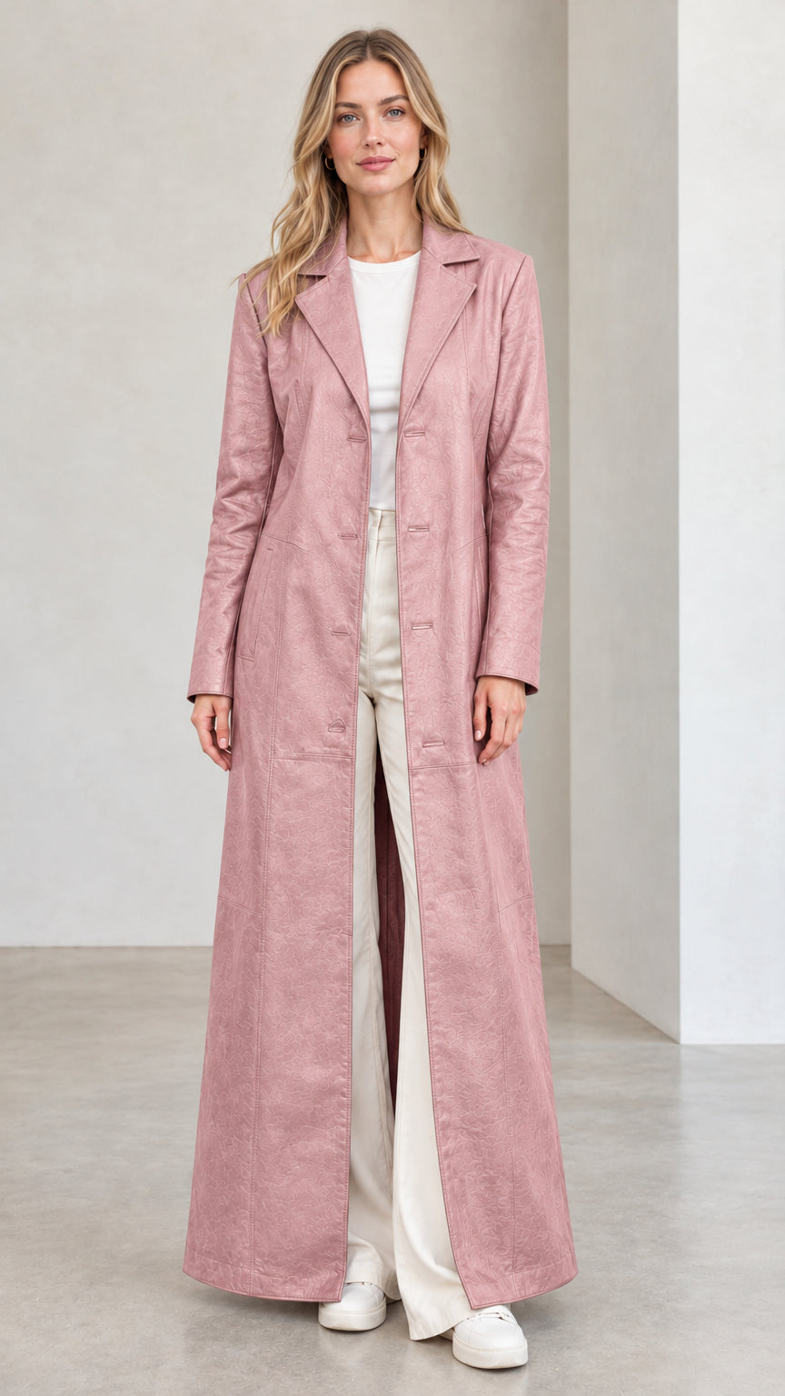 Front full view of woman wearing dusty pink full-length faux leather trench coat