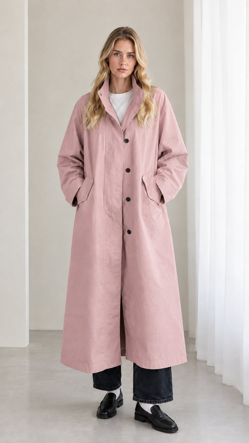 Front view of woman wearing dusty pink longline trench overcoat