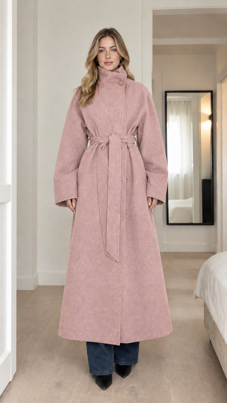 Front full-length view of model wearing dusty pink high-neck belted maxi coat