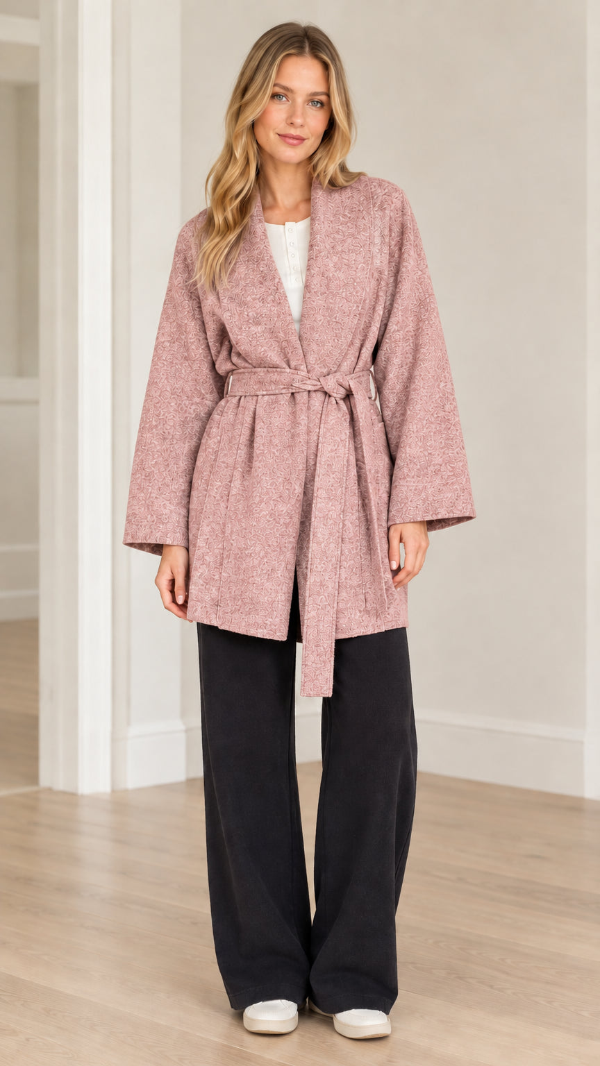 Front view of model wearing dusty pink textured herringbone belted wrap coat