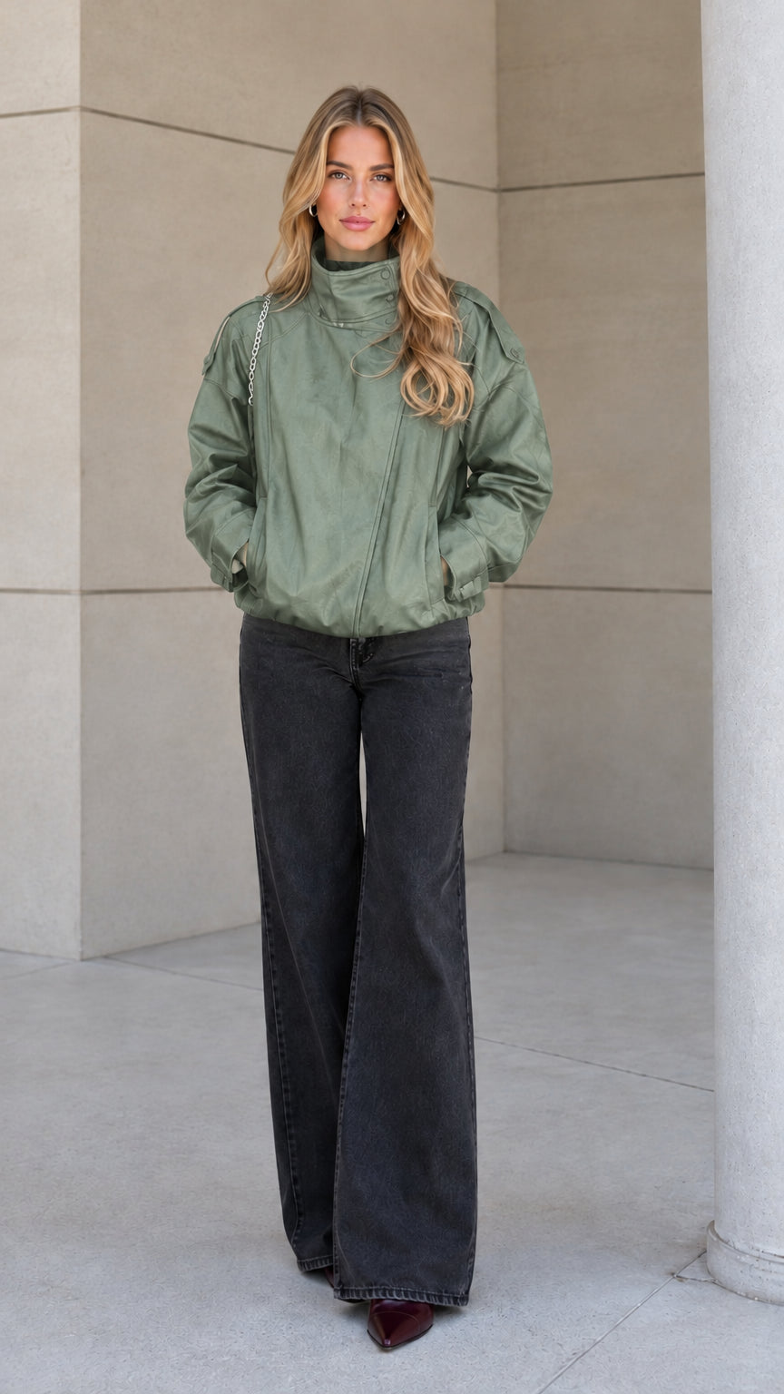 Front view of model wearing the sage green high-neck zip-up bomber jacket