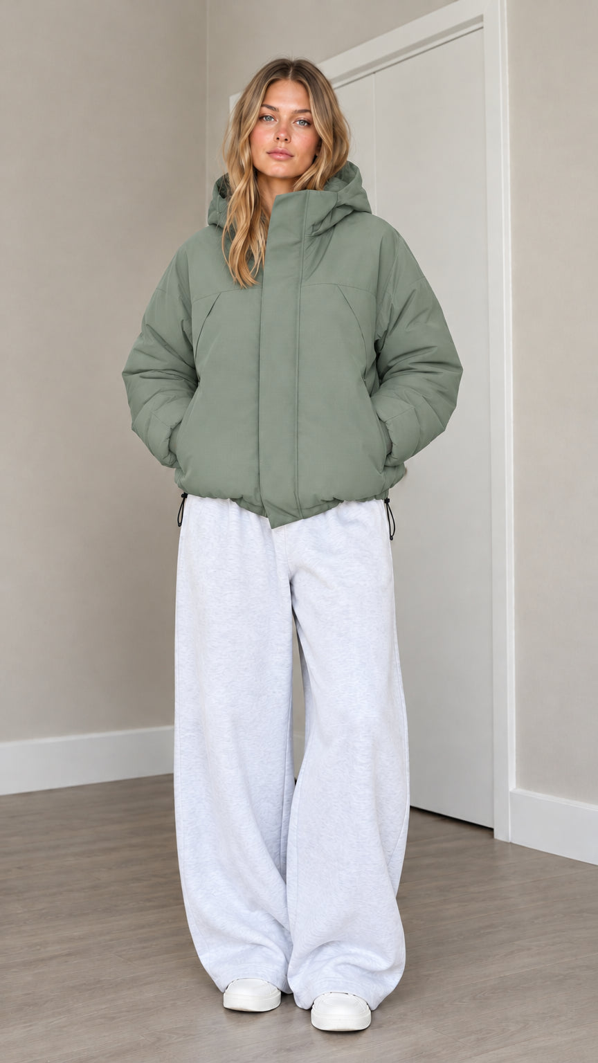 Front view of model wearing sage green hooded puffer jacket