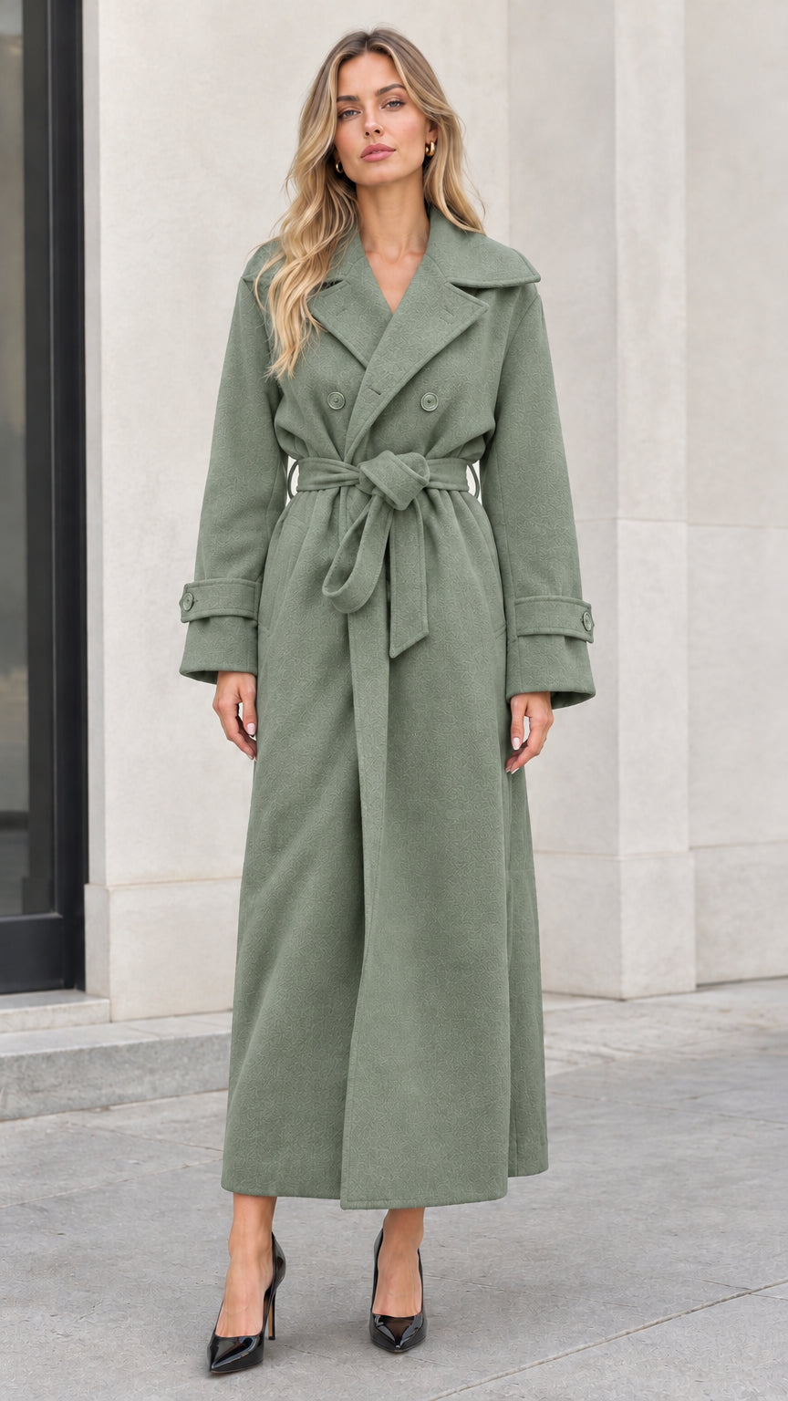 Front full-length view of woman wearing sage green double-breasted belted maxi coat