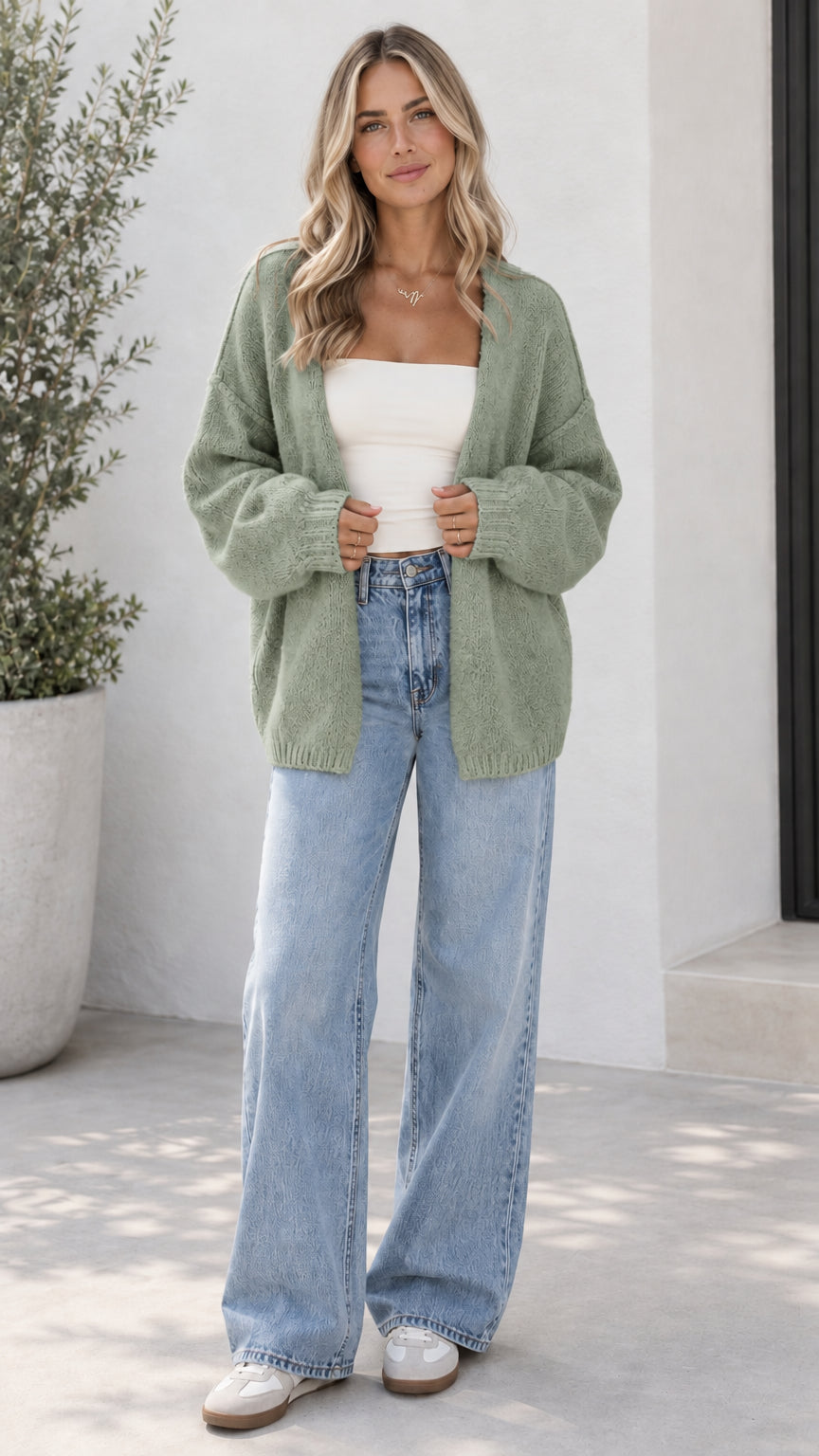 Model wearing sage green open front oversized knit cardigan with light blue jeans