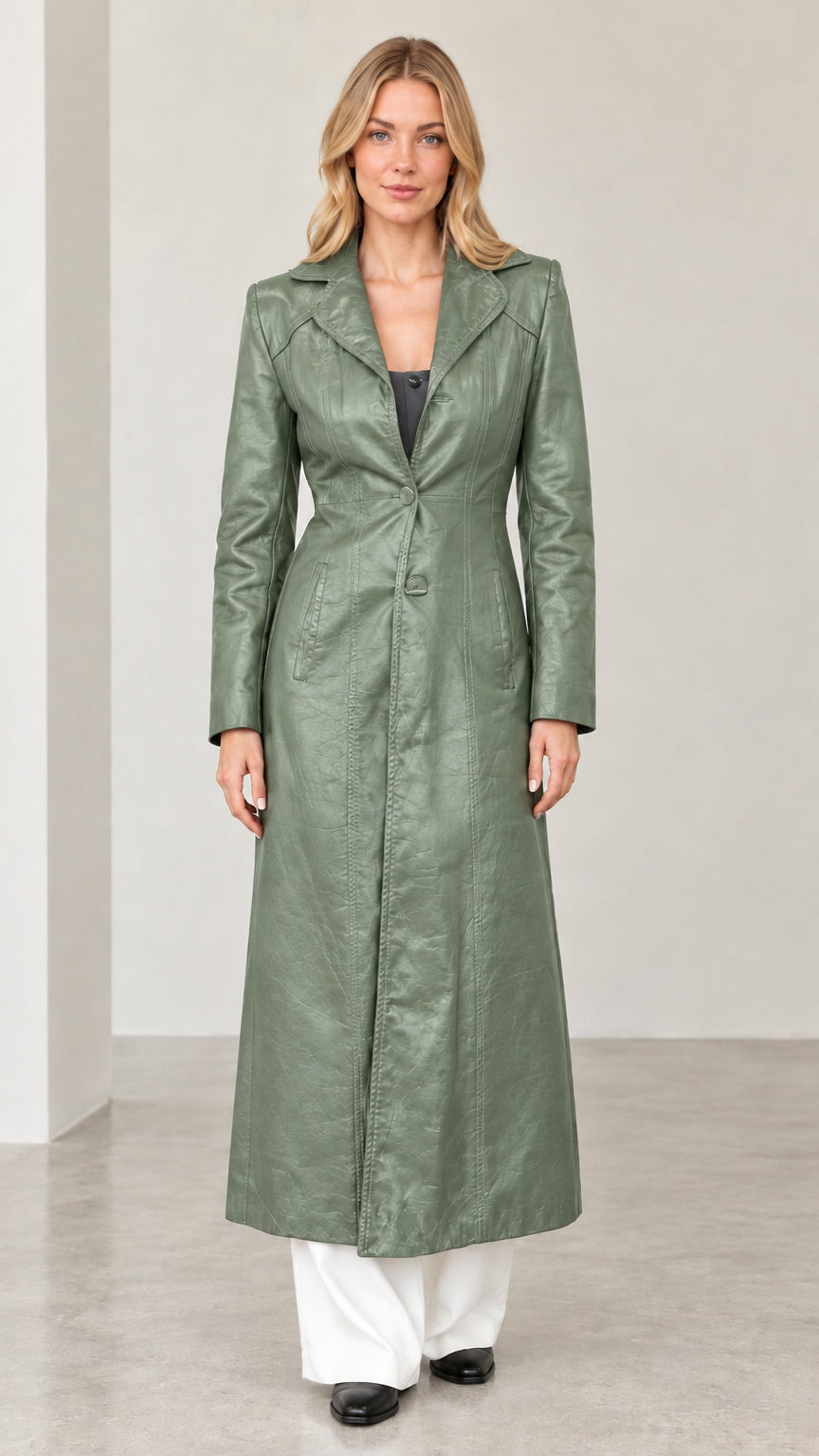 Full-length front view of woman wearing sage green textured faux leather long trench coat