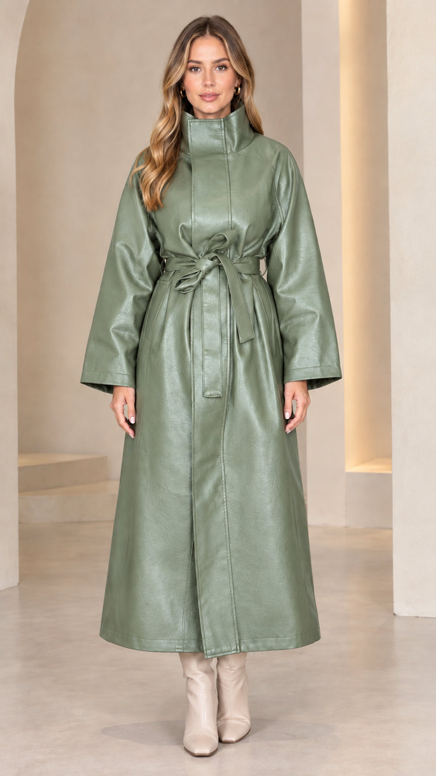 Front view of model wearing sage green high neck belted faux leather maxi coat