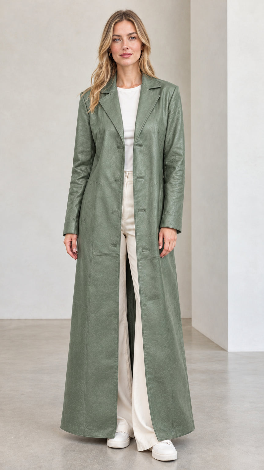 Front full view of woman wearing sage green full-length faux leather trench coat