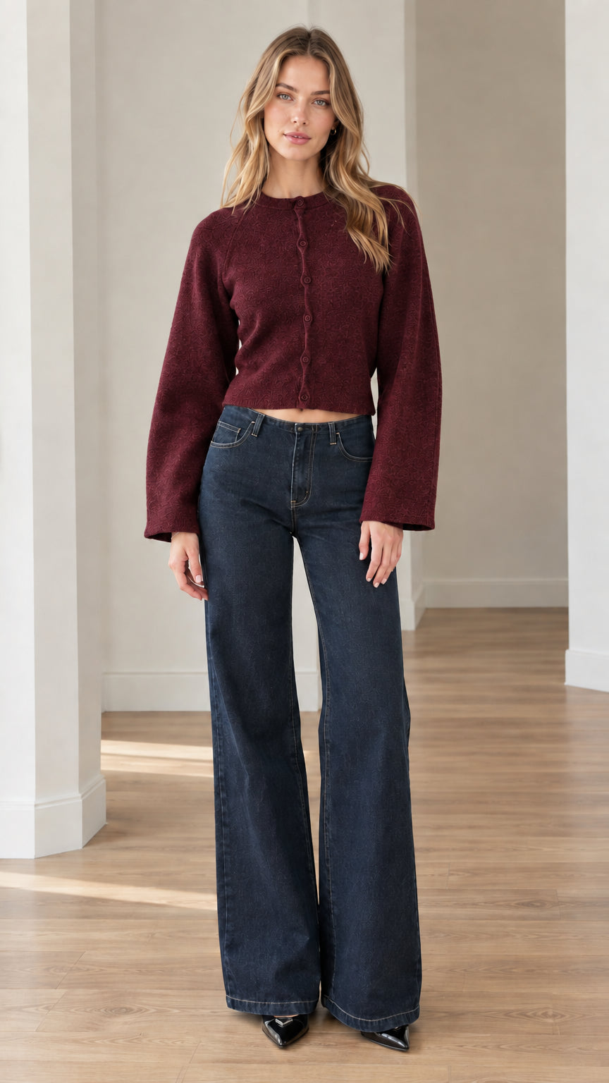 Model wearing burgundy wine red cropped knit cardigan with dark denim jeans