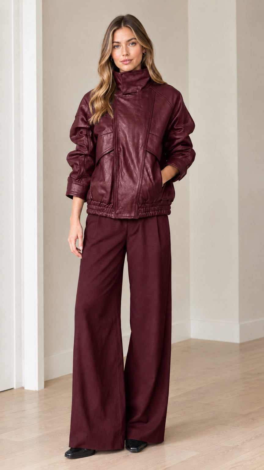 Front view of model wearing burgundy faux leather bomber jacket and wide-leg pants set