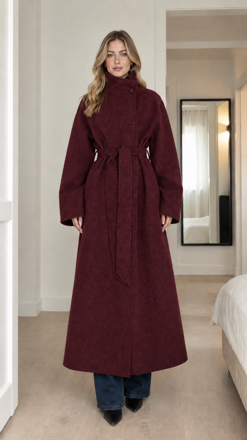 Front full-length view of model wearing burgundy wine high-neck belted maxi coat