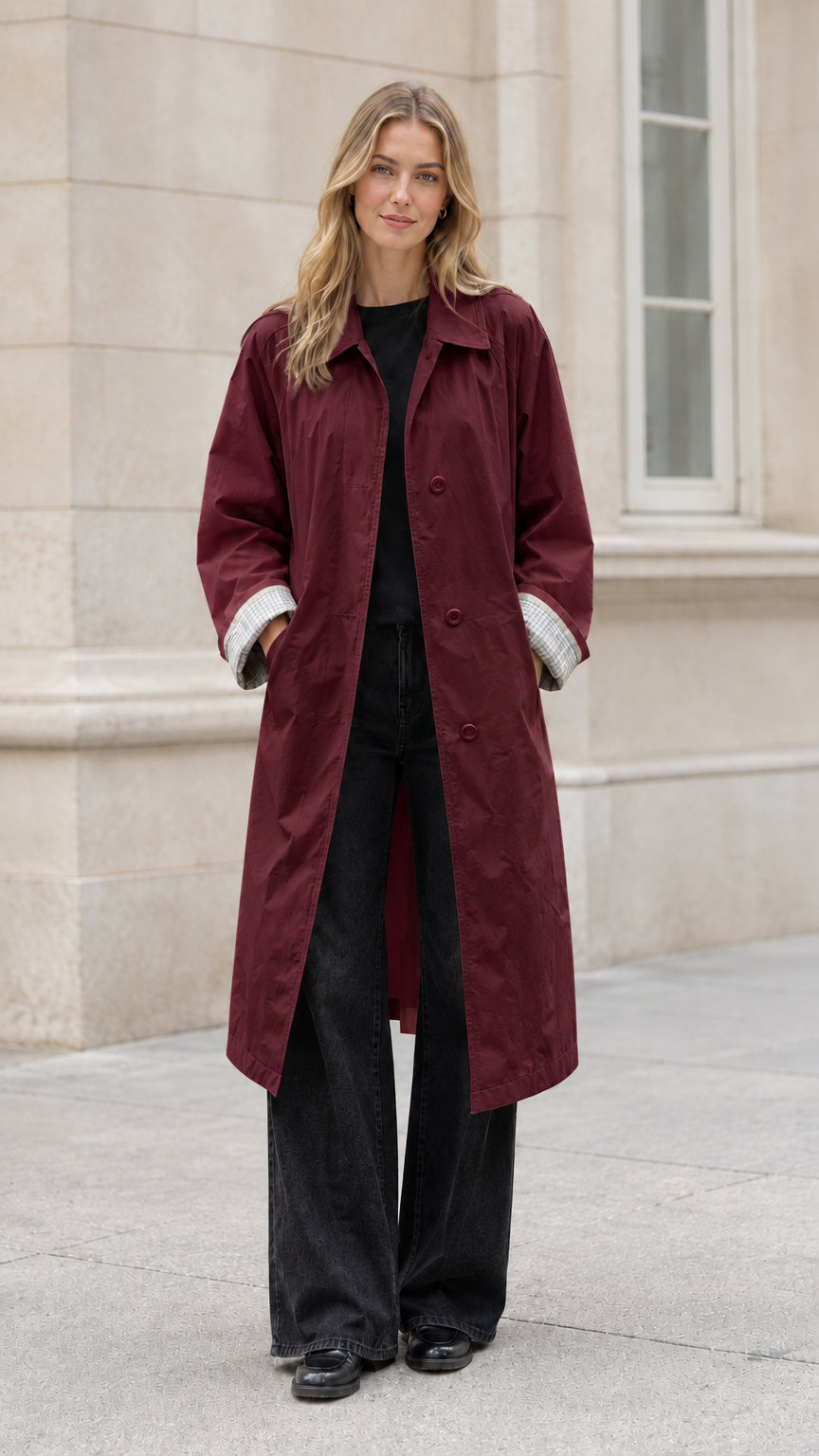 Front full-length view of model wearing a burgundy wine red long belted trench coat