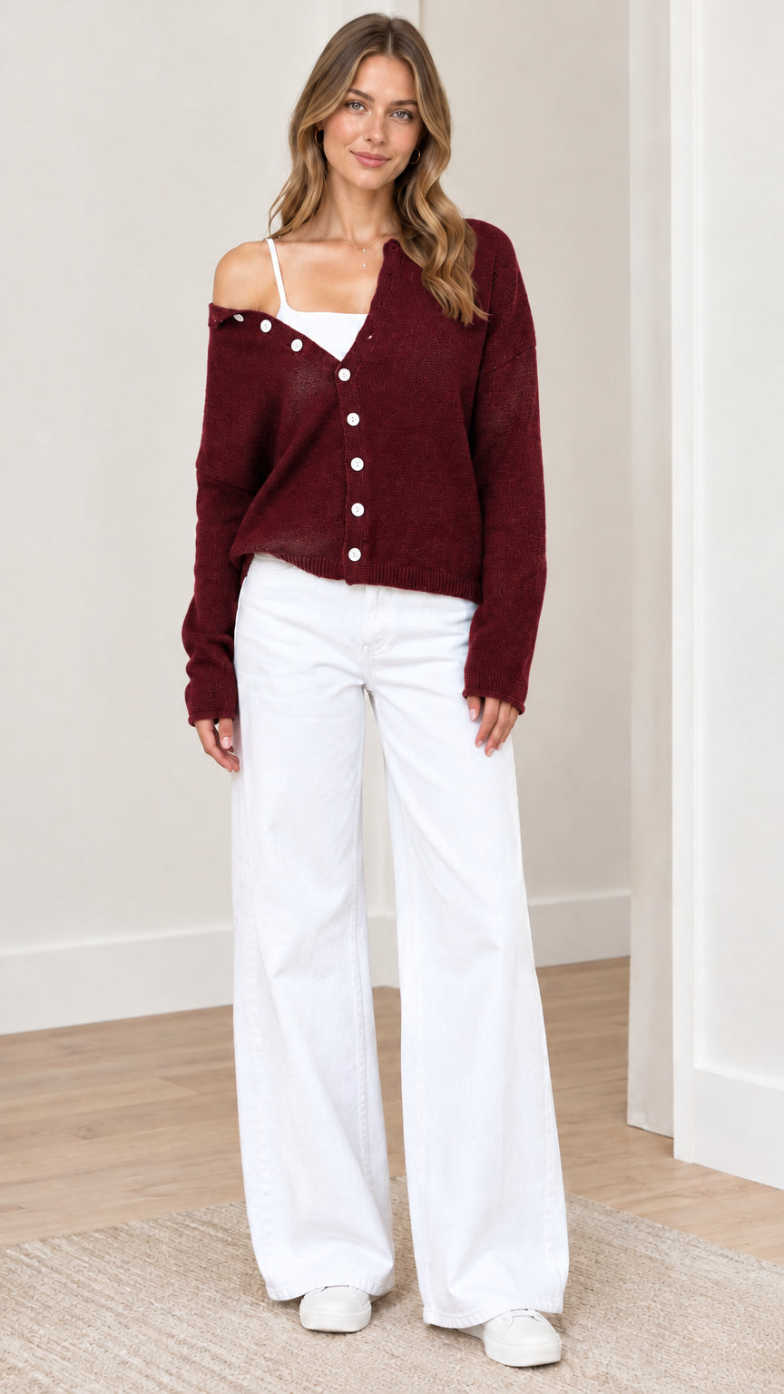 Front view of woman wearing burgundy wine red asymmetrical button-down knit cardigan sweater