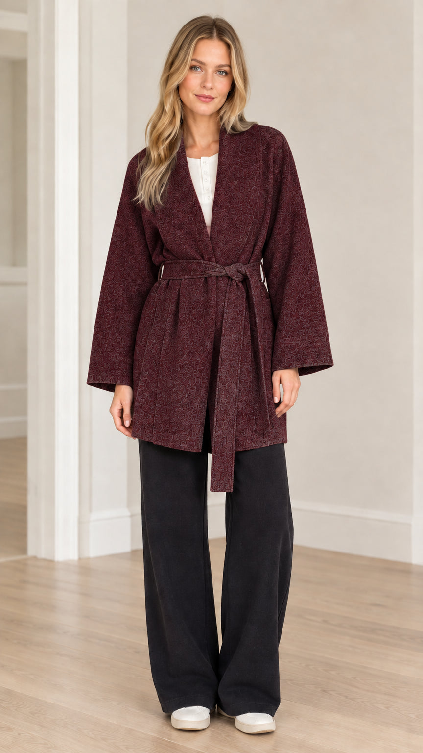 Front view of model wearing burgundy textured herringbone belted wrap coat