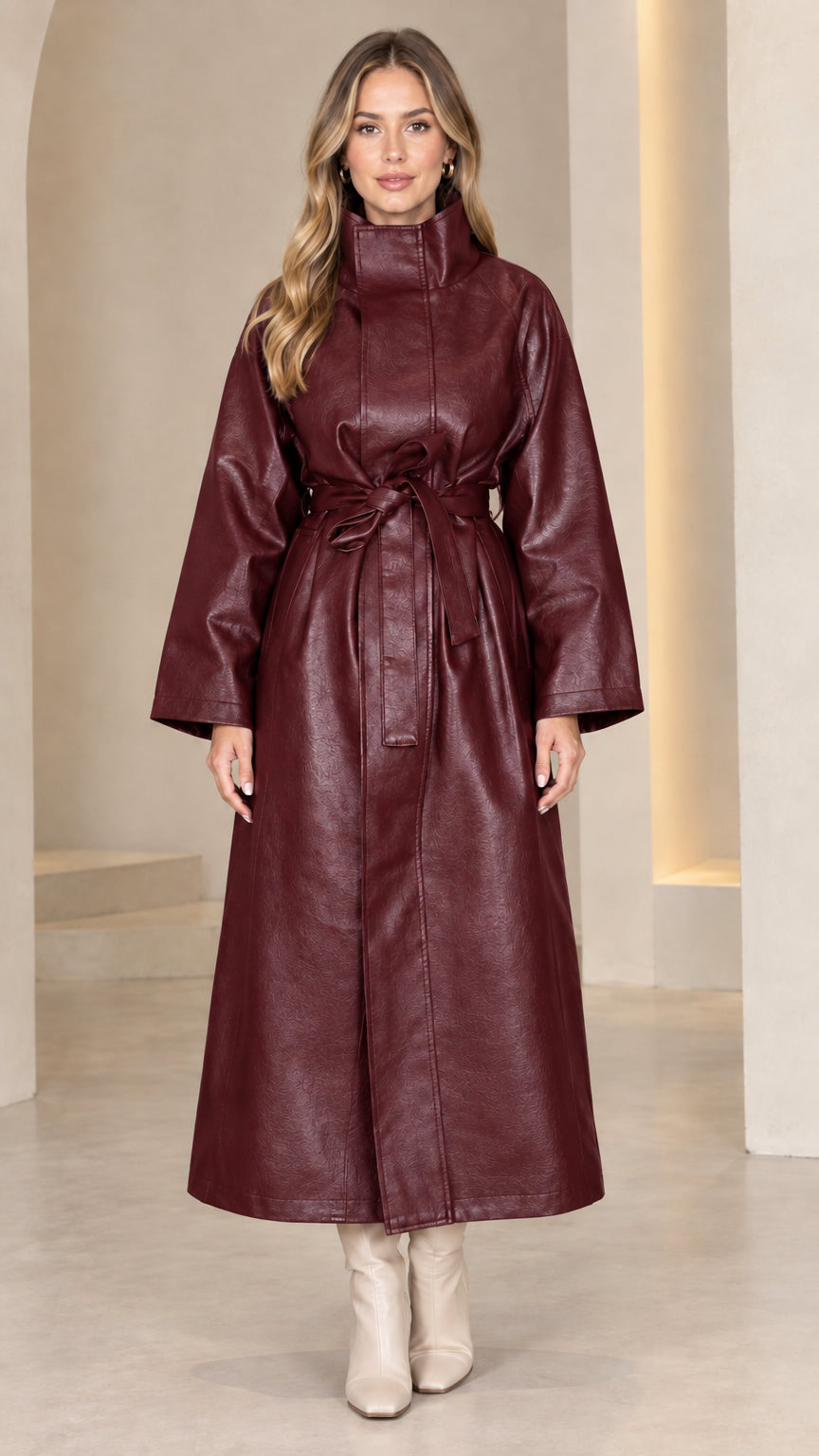 Front view of model wearing deep burgundy belted faux leather maxi trench coat