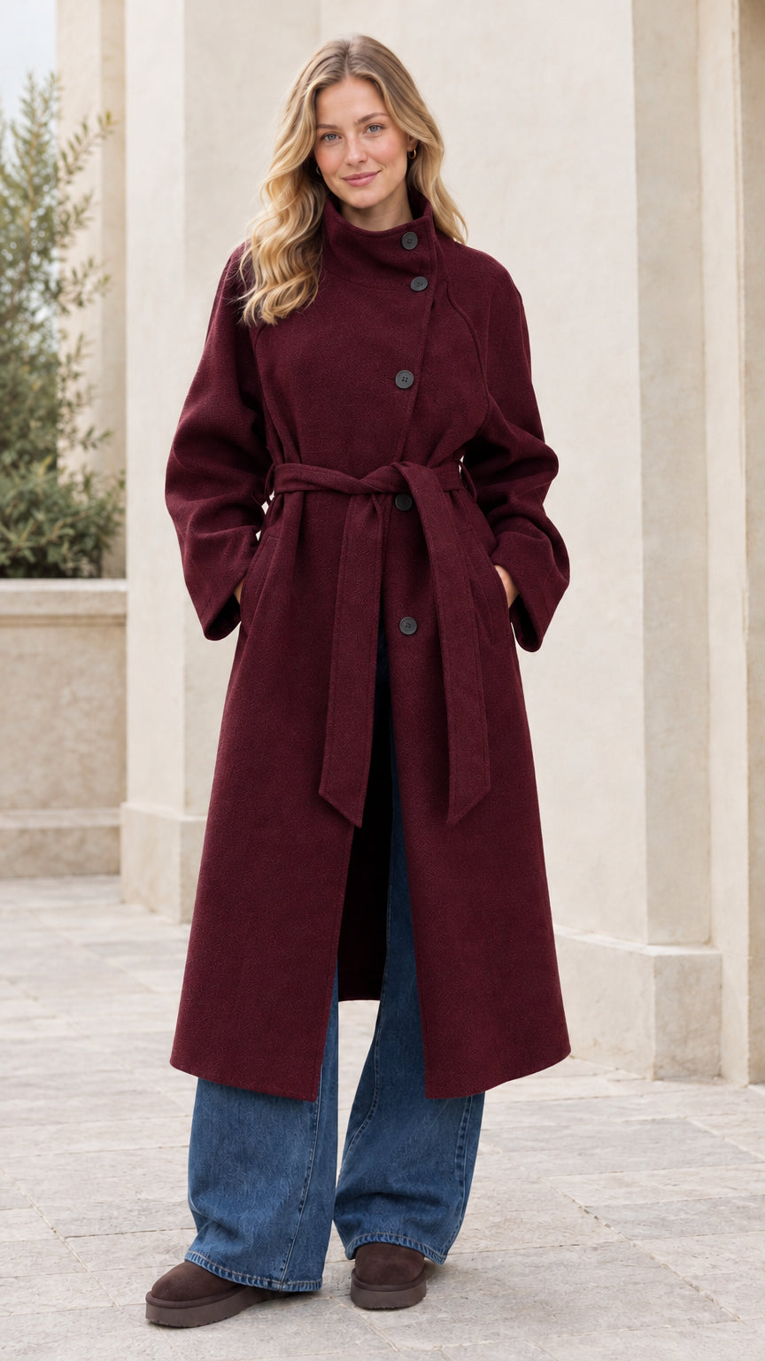 Front full view of woman wearing the burgundy wine asymmetrical high-neck belted overcoat