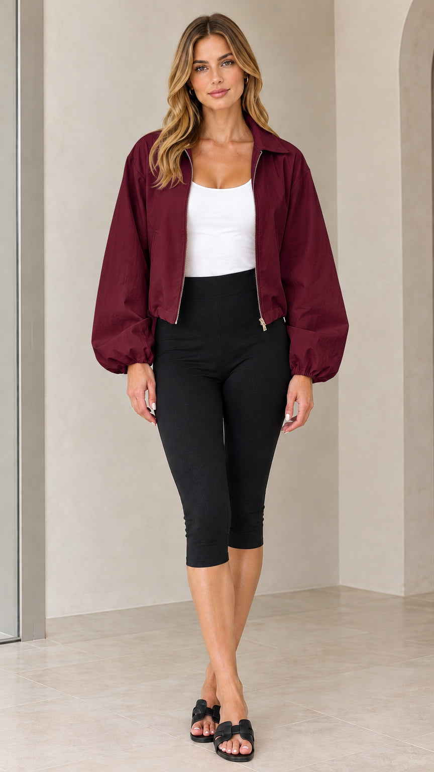 Front view of model wearing burgundy cropped zip-up jacket