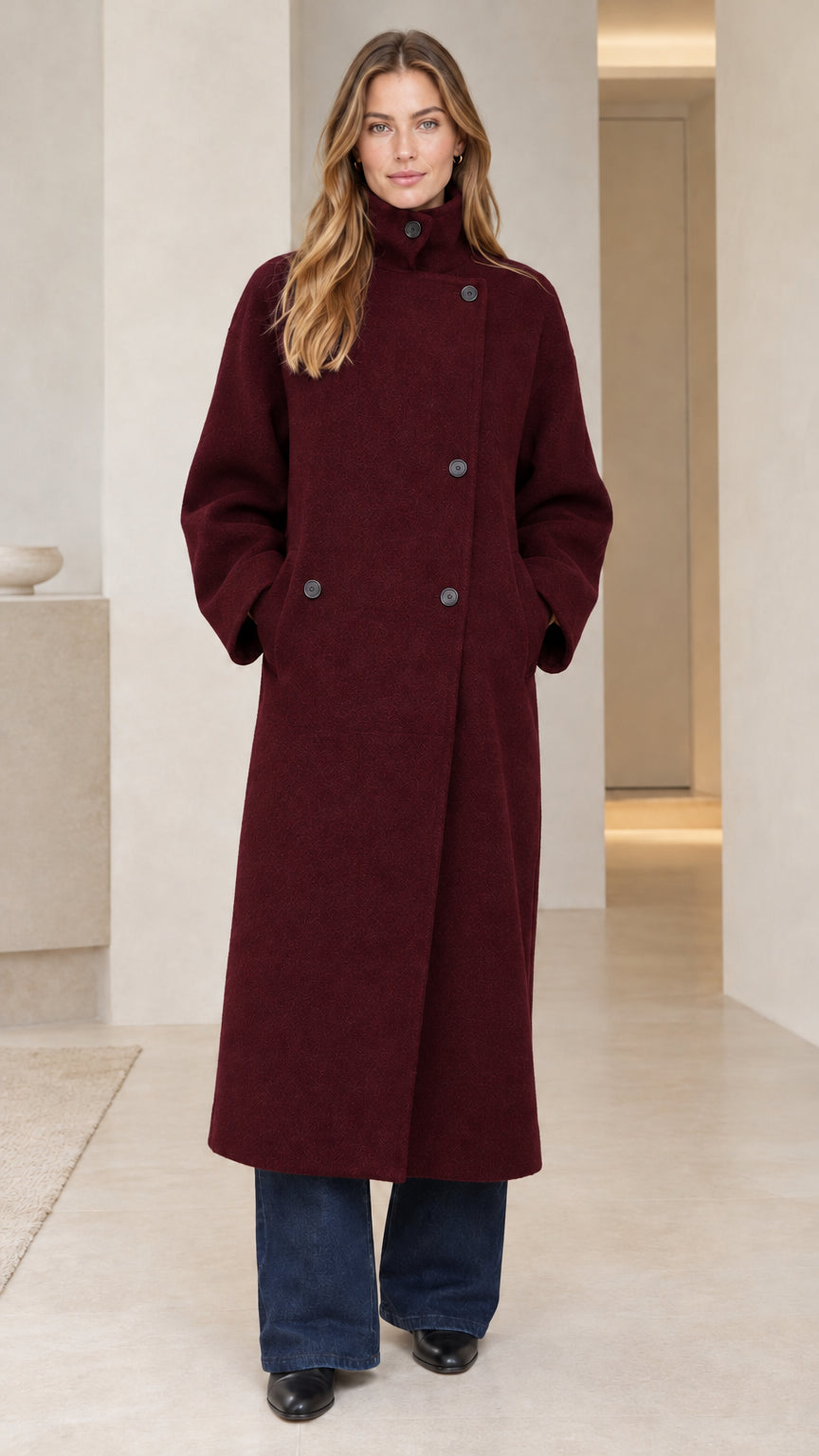 Front view of model wearing rich burgundy wine red asymmetric button long overcoat