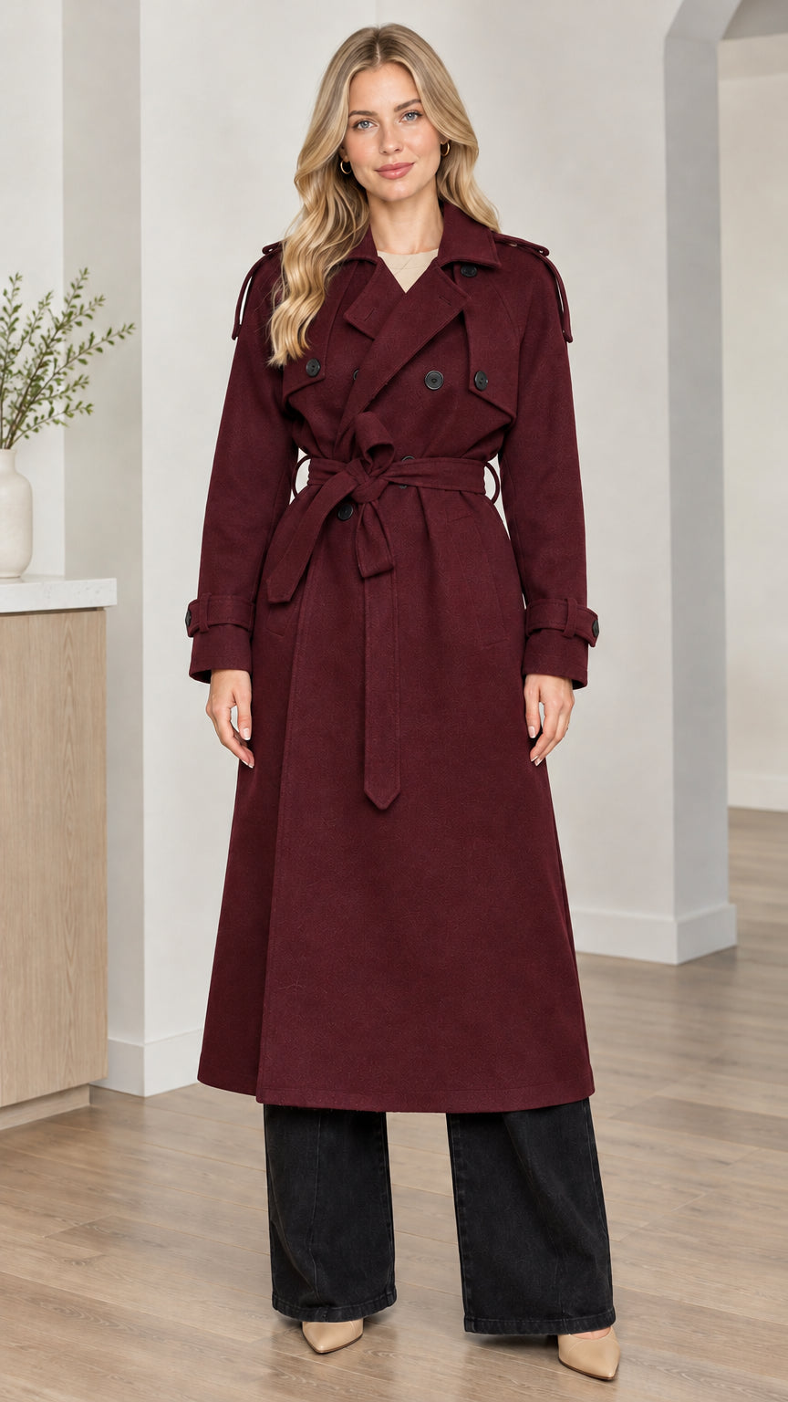 Front full-length view of woman wearing burgundy wine red double-breasted long trench coat with tie belt