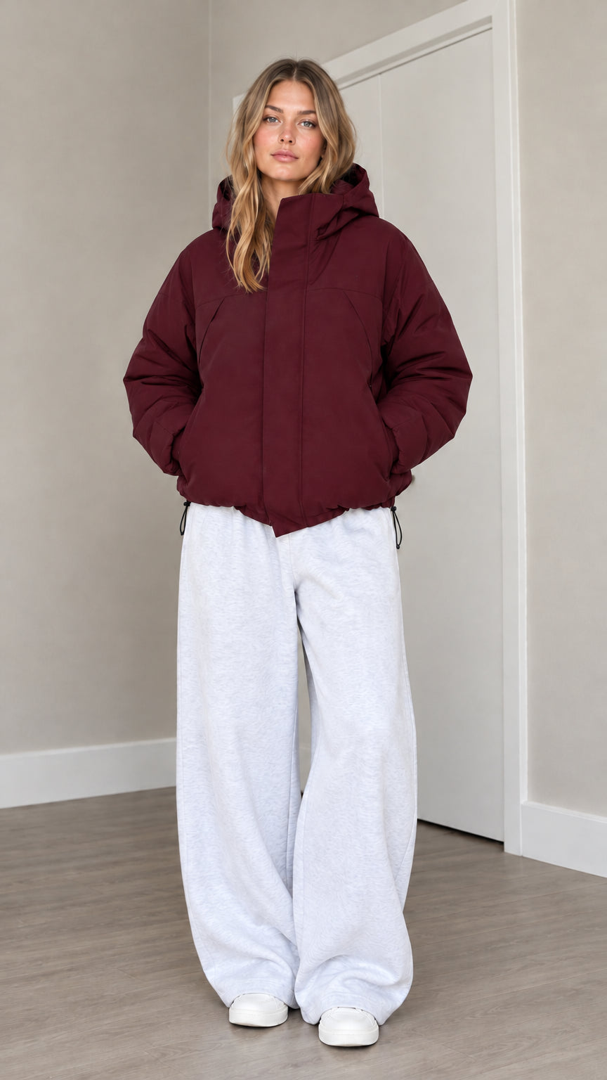 Front view of model wearing burgundy hooded puffer jacket