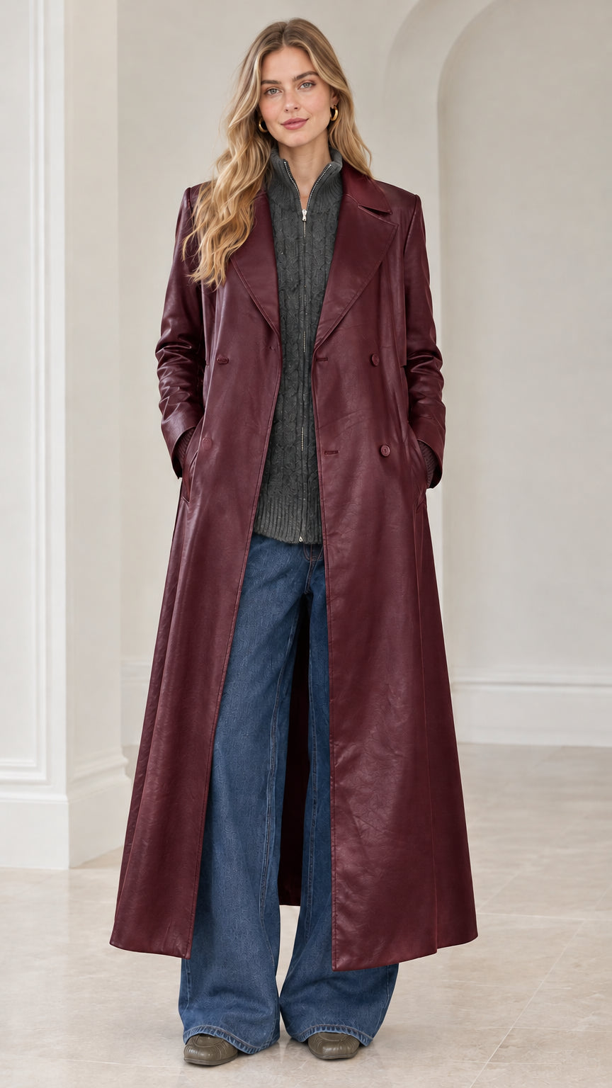 Full-length front view of model wearing deep burgundy red faux leather maxi trench coat