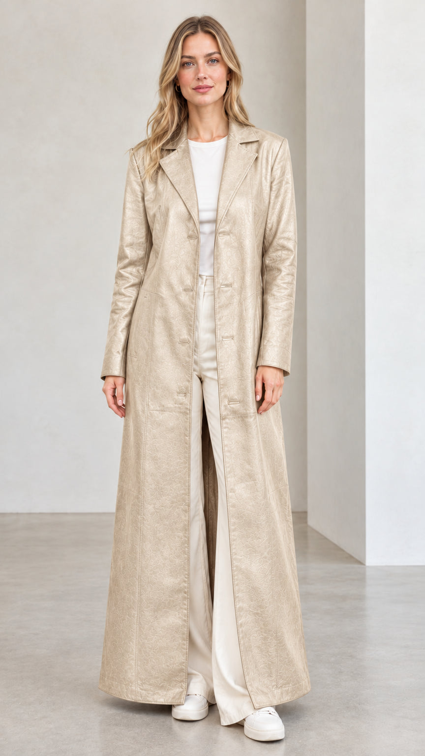 Front full view of woman wearing champagne beige full-length faux leather trench coat