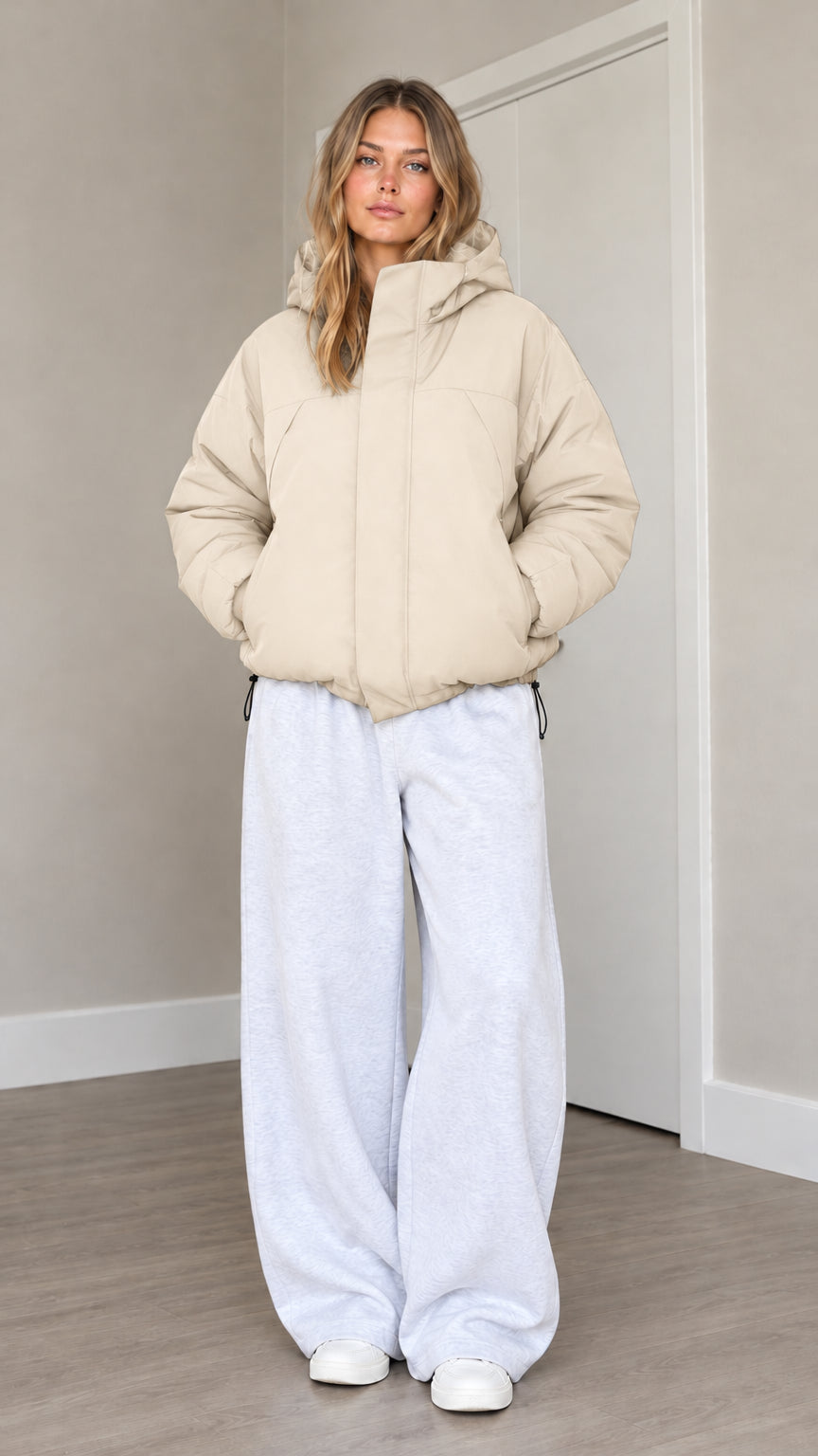 Front view of model wearing beige cream hooded puffer jacket