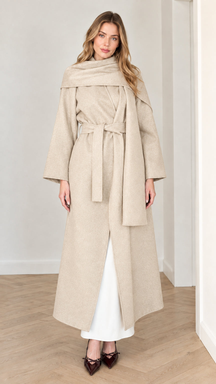 Model wearing elegant beige oatmeal maxi wrap coat with attached scarf detail