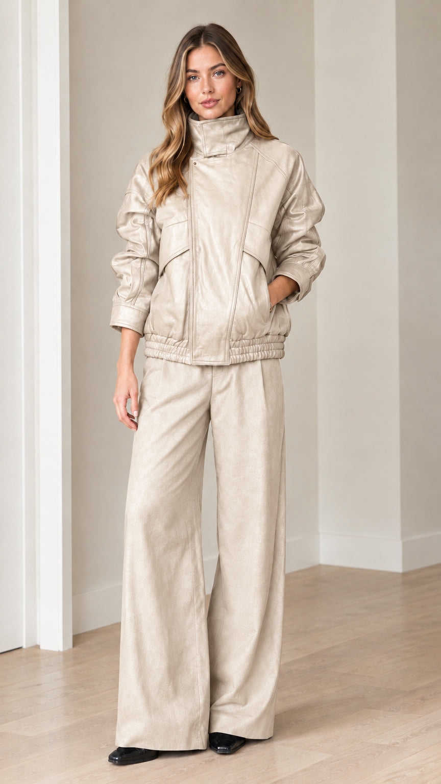 Front view of model wearing beige faux leather bomber jacket and matching pants set